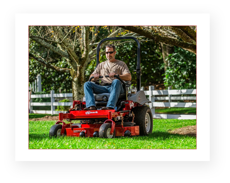 A man sitting on top of a red lawn mower.