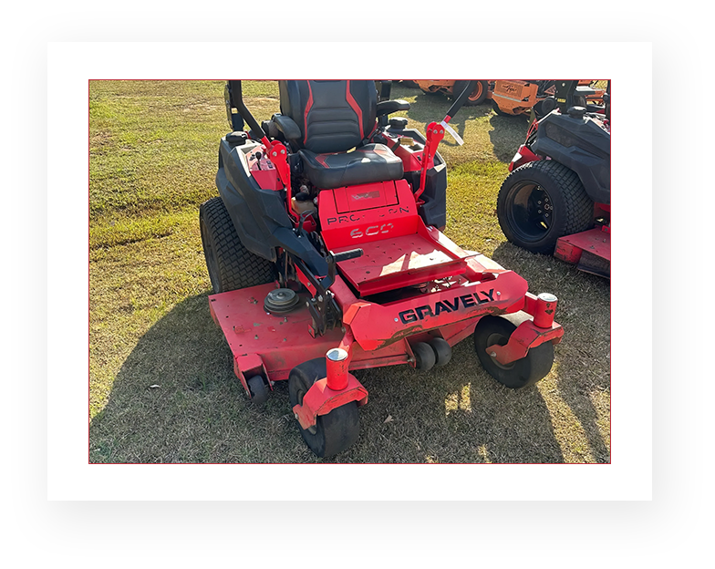 A red lawn mower sitting on top of grass.