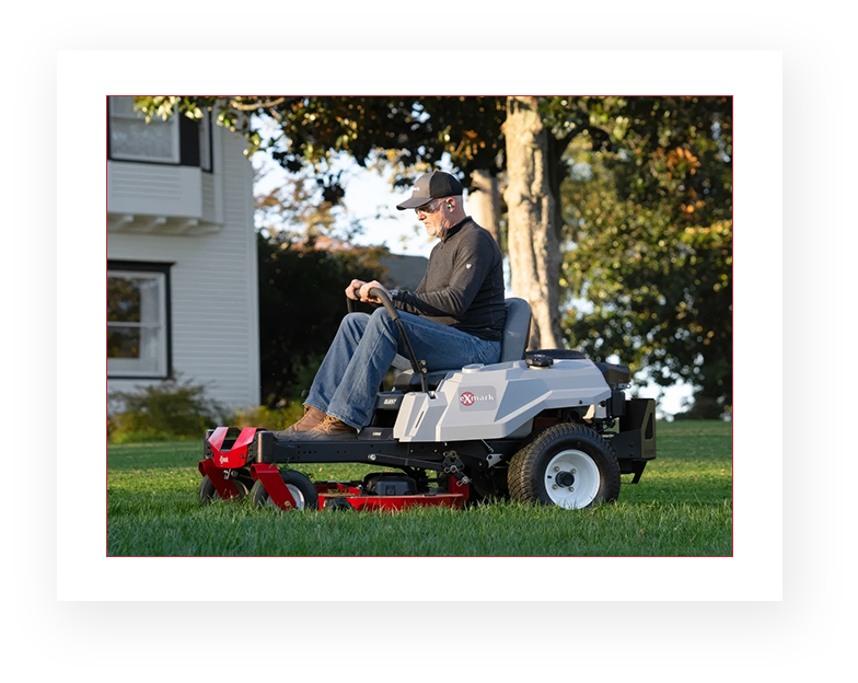 A man riding on the back of a lawn mower.